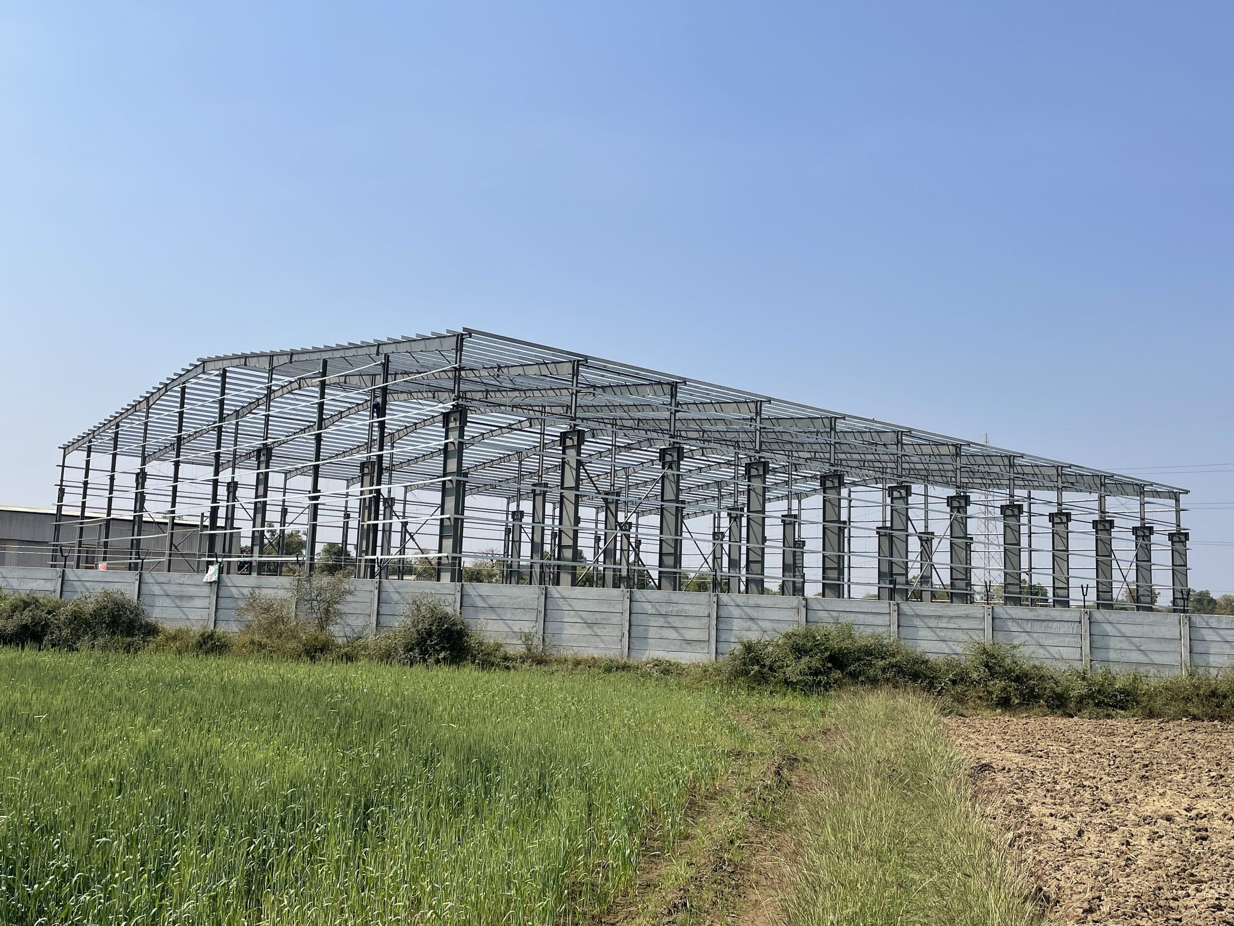 PEB steel frame beside farmland by AcuFabInfraStructure